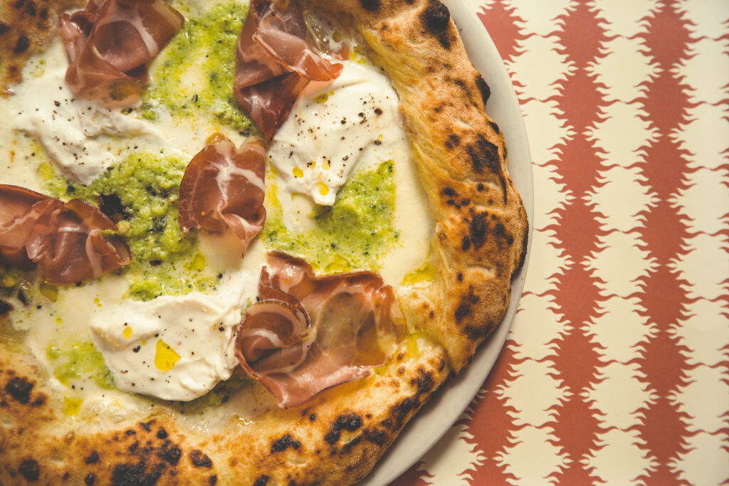 Pizze Regionali_i sapori del Sud_La Pugliese con Capocollo, burrata, pesto di zucchine con Mandorle su tovaglietta rossa di Fornace Stella